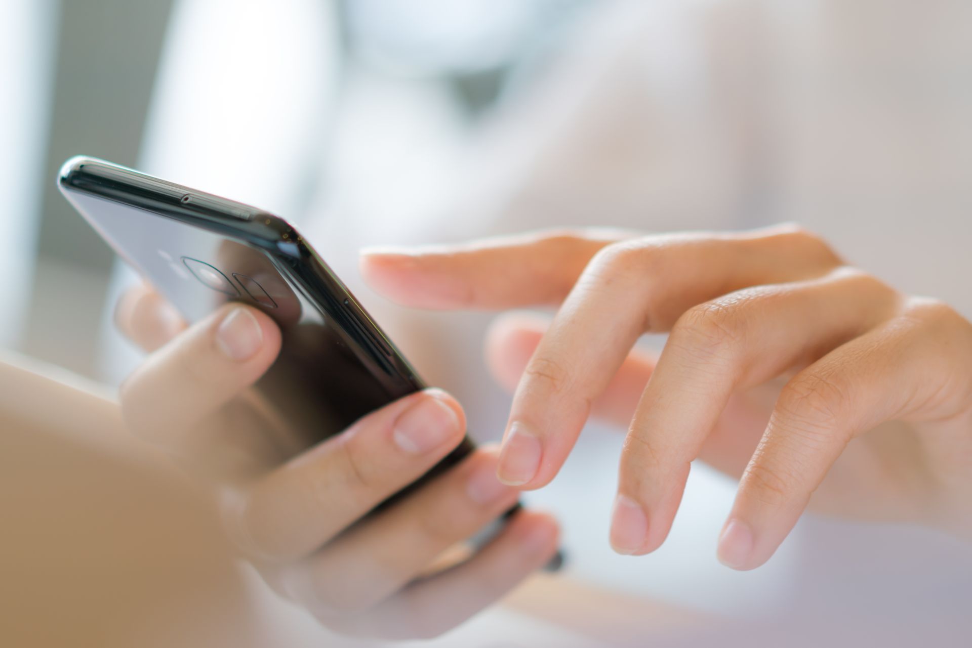 Cropped Image of a woman hand dailing on her modern Smartphone